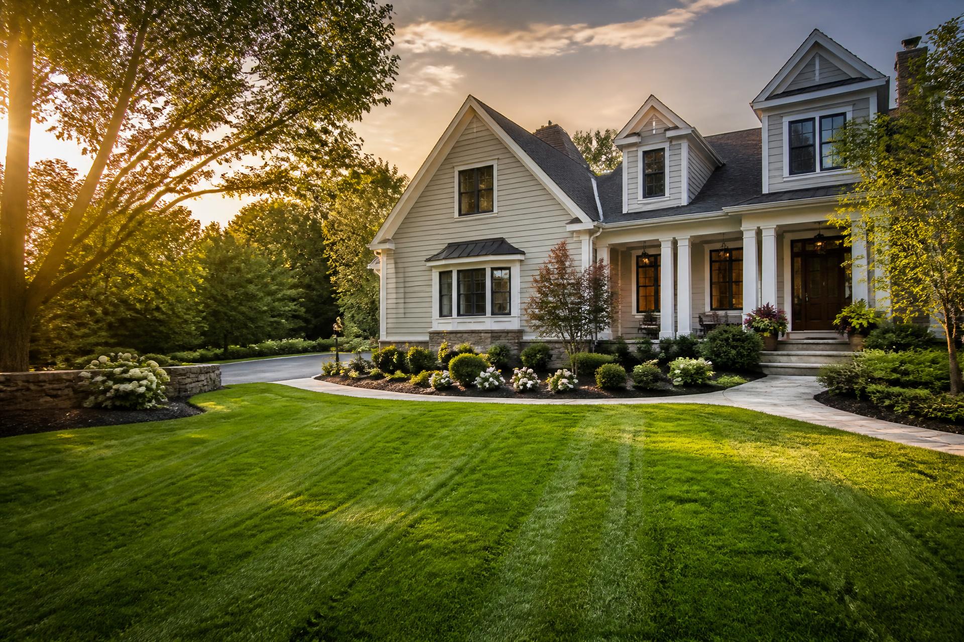 Professionally landscaped front yard with a striped lawn and fresh mulch beds in Pawtucket, Rhode Island